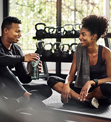 Photo of woman sitting next to trainer after workout