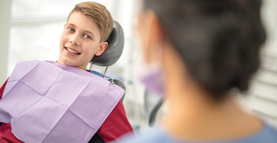 Photo of boy in dentist's chair with hygienist